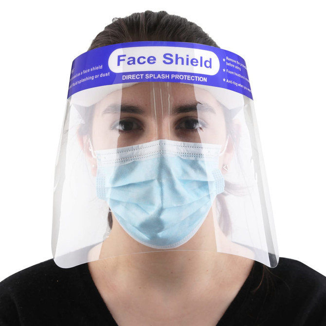 A protective face shield made of clear plastic, worn over a blue surgical mask, features a logo on the top.