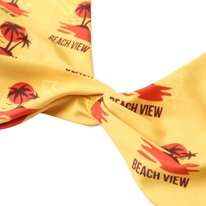 A yellow bikini top with a knot detail, featuring palm tree and beach-themed designs. It has a logo.