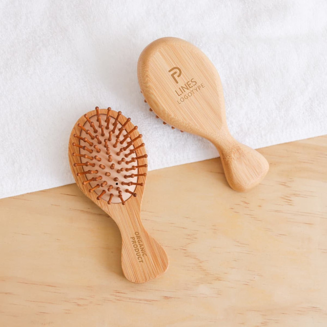A small bamboo hairbrush with wooden bristles, featuring a smooth handle and branded logo.