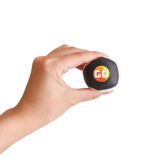 A hand holding a black and white Hacky Sack featuring a colourful logo.