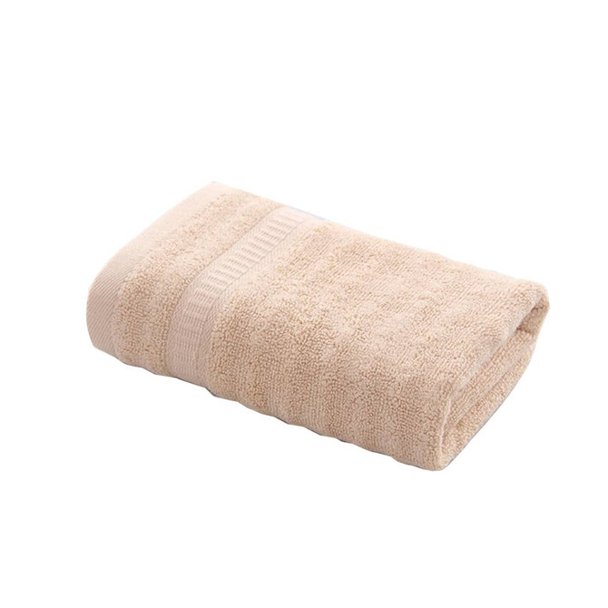A folded bamboo fibre towel in a light beige shade, featuring a textured surface. The towel is neatly arranged.