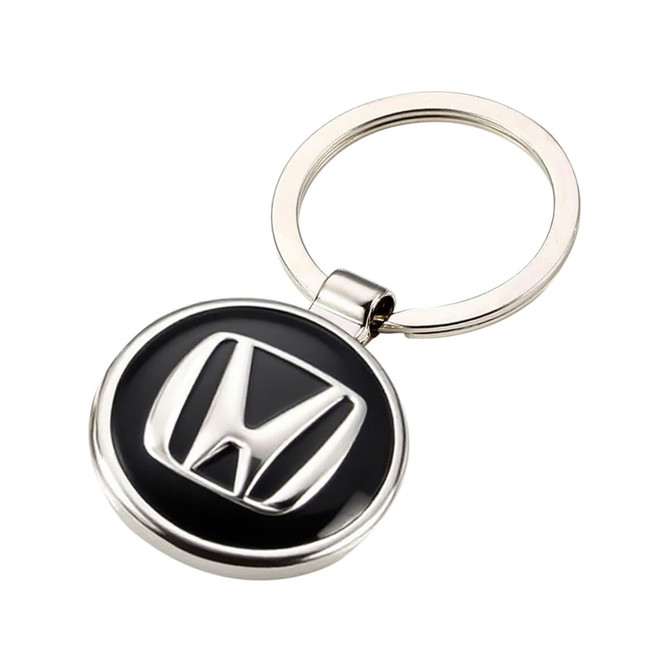 A silver keyring featuring a round black and silver embossed logo. The keyring has a smooth finish and a metal loop.