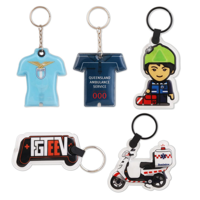 A PVC LED keyring set featuring a shirt, ambulance, character, game controller, and scooter design in various colours.