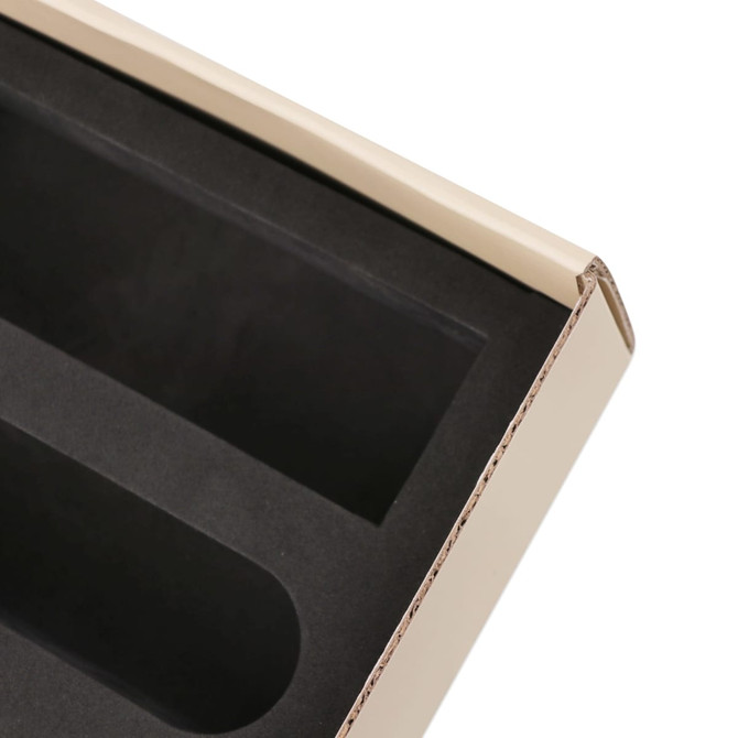 A beige subscription box with a black interior, featuring two compartments for product organisation.