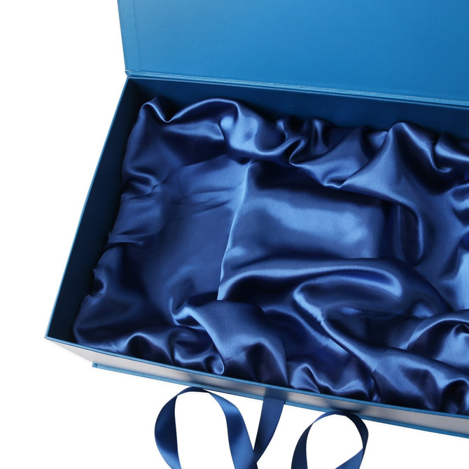 A custom gift box in blue, featuring a satin interior lining and decorative ribbon.