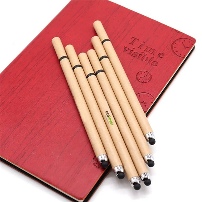 A set of brown eco-friendly stylus pens with touch heads arranged on a red notebook featuring a raised design and logo.