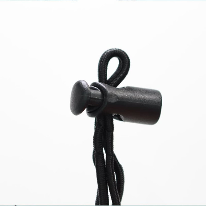 A black toggle and cord for securing items, featuring a rounded end and adjustable design.