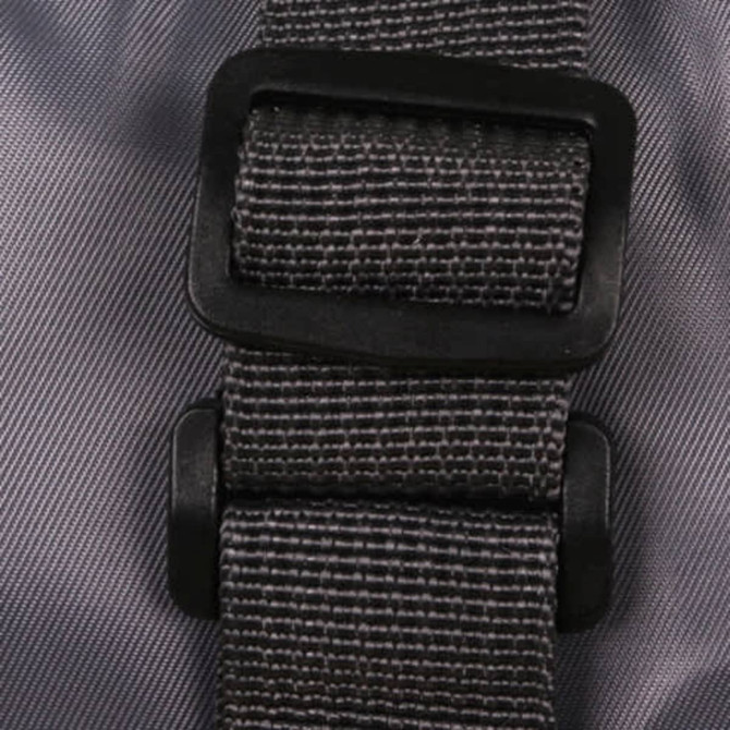 A grey travel compressed bag featuring a sturdy black buckle and strap for secure fastening.