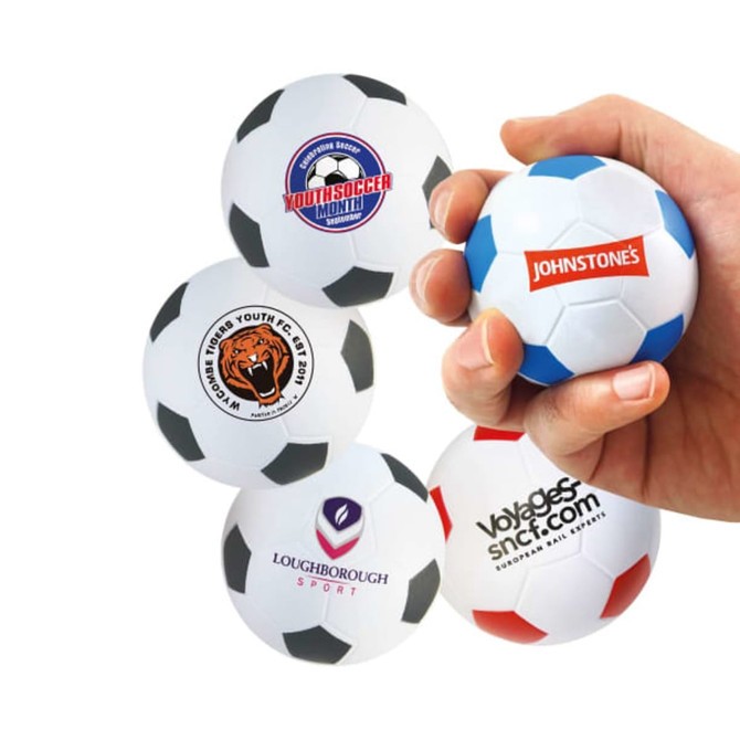 A hand squeezes a 63mm white and black football-shaped stress reliever, featuring various logos.