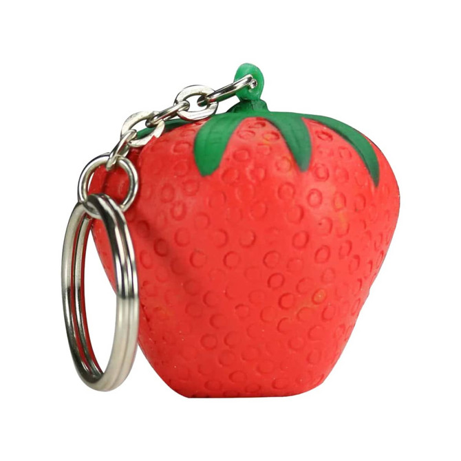 A red strawberry-shaped stress reliever attached to a silver keyring, featuring green leaves on top.