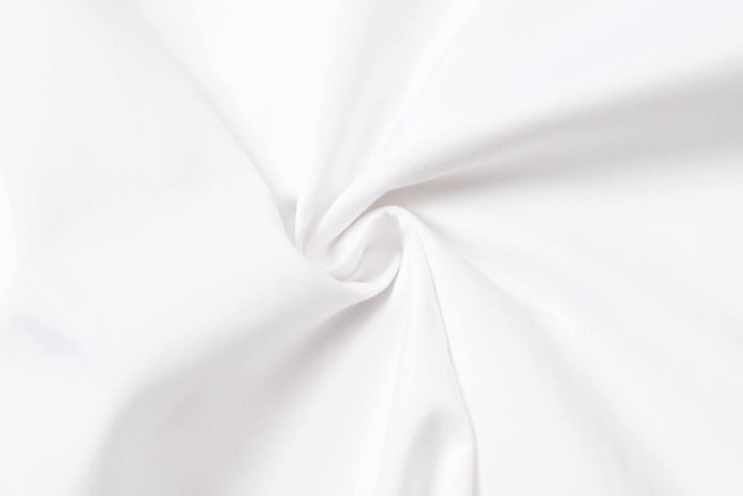 A white fabric featuring a smooth texture, folded in a spiral formation, ideal for uniforms.