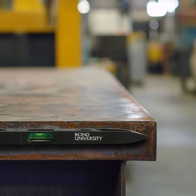 A magnetic torpedo level in black rests on a metal surface, featuring a liquid vial for measuring.