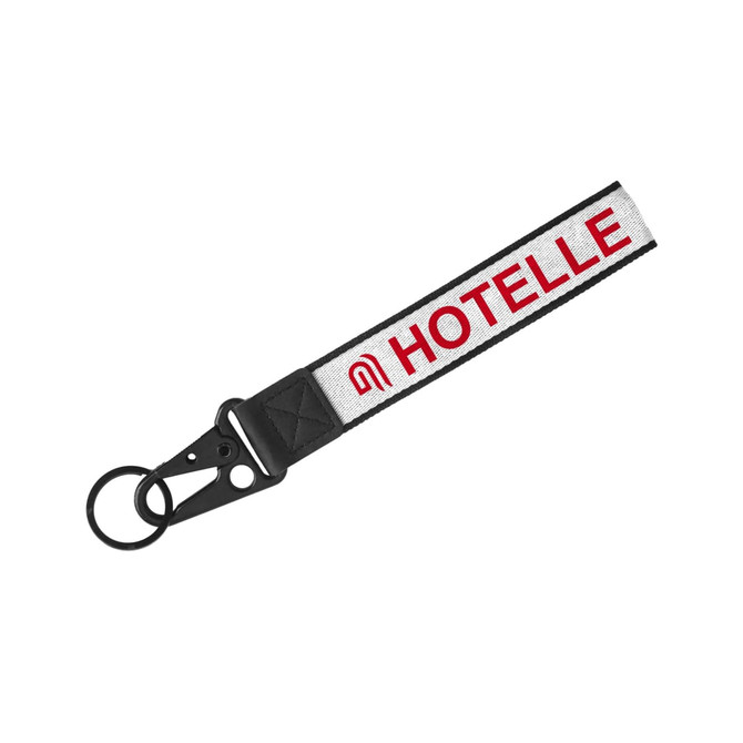 A Jacquard keyring featuring a black strap with a woven design and a circular keyring attachment. A Jacquard keyring featuring a black strap with a woven design and a circular keyring attachment.