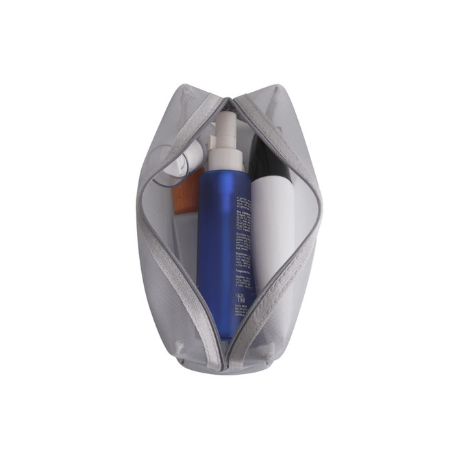 A grey nylon mesh cosmetic bag with various beauty products, including a blue spray bottle and a white container.