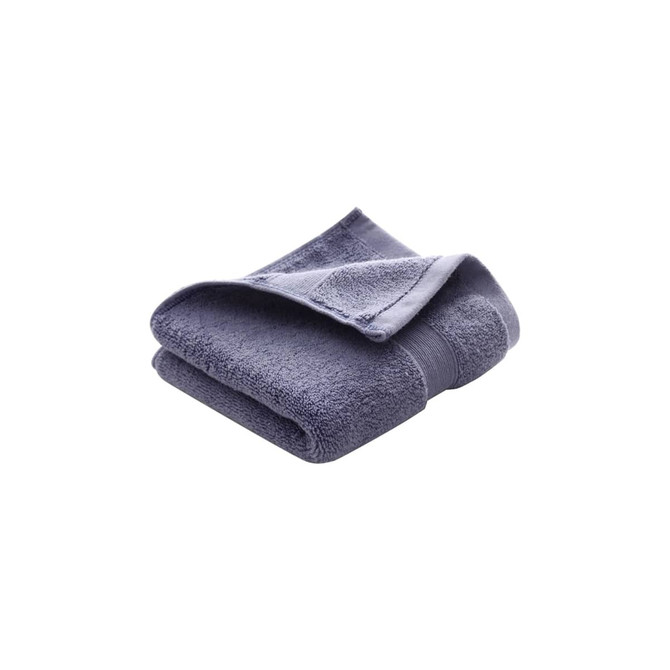 A folded embroidered cotton hand towel in a deep blue colour with a textured finish. Features a logo.