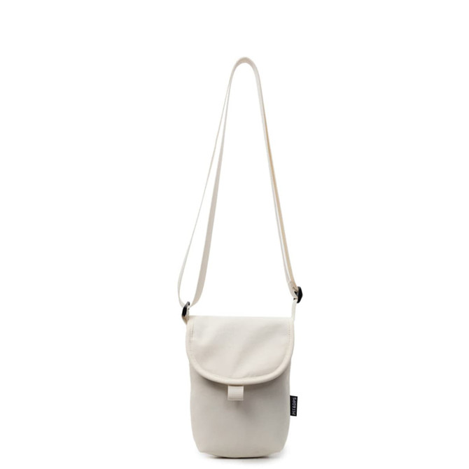 A small size canvas shoulder bag in light cream with a flap closure and an adjustable strap. Features a logo.