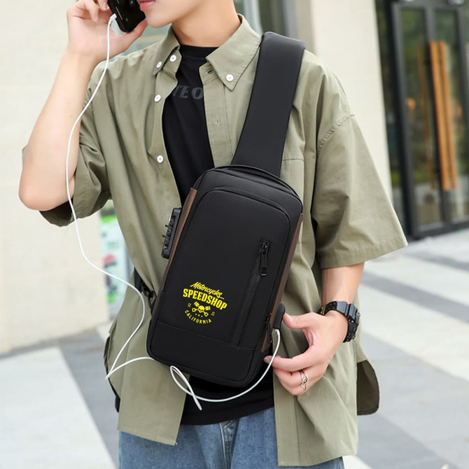A black anti-theft sling bag worn over a person's shoulder, featuring a logo and an earphone cord.