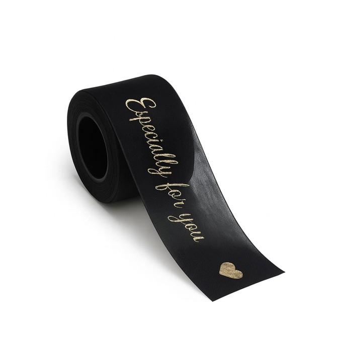 A roll of black organza ribbon featuring gold text that reads "Especially for you" and a heart design.