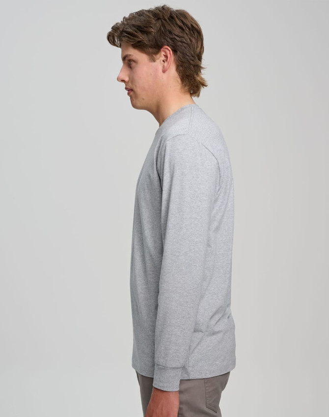 A grey long-sleeve T-shirt displayed on a model from the side, featuring a simple design and a logo.