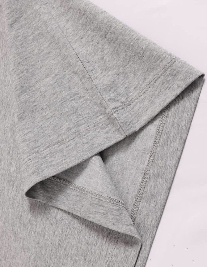 A close-up of a grey long-sleeve cotton tee shirt, featuring a stitched hem and smooth fabric texture.