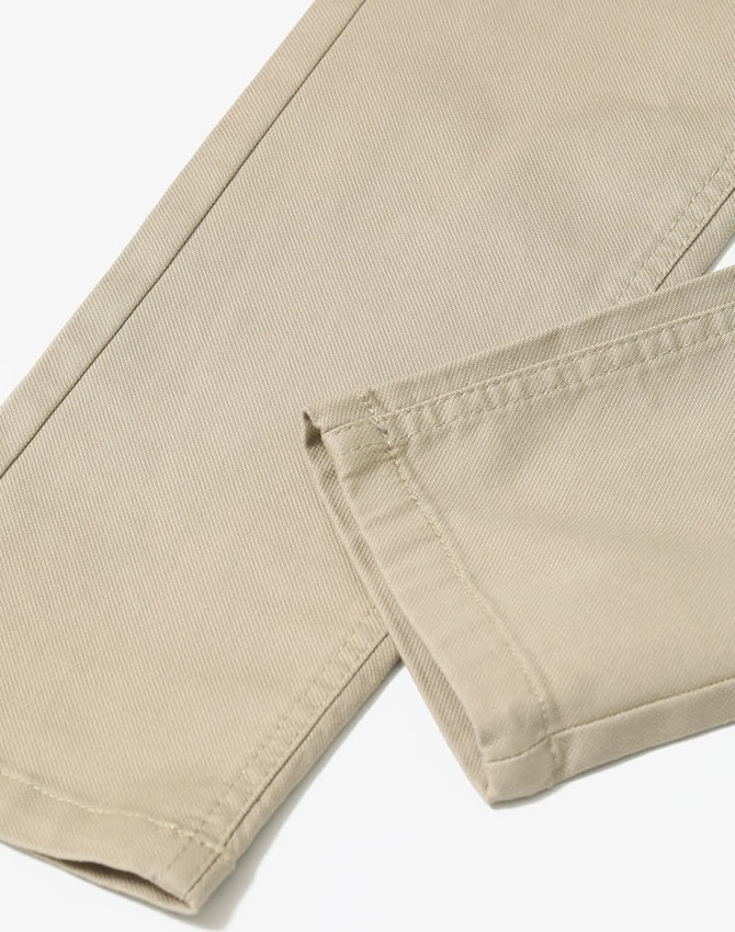 Flexi chino pants in a beige colour, featuring a tailored cut and visible stitching details. Includes a branding logo.