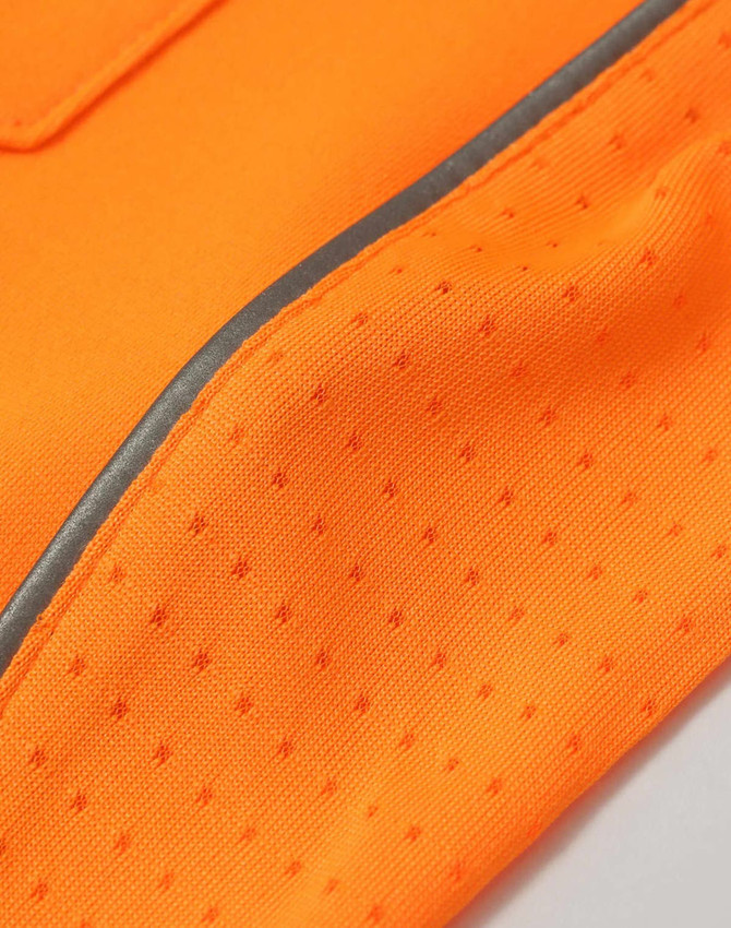 A close-up of an orange fabric with a mesh texture and a reflective trim, featuring a logo.