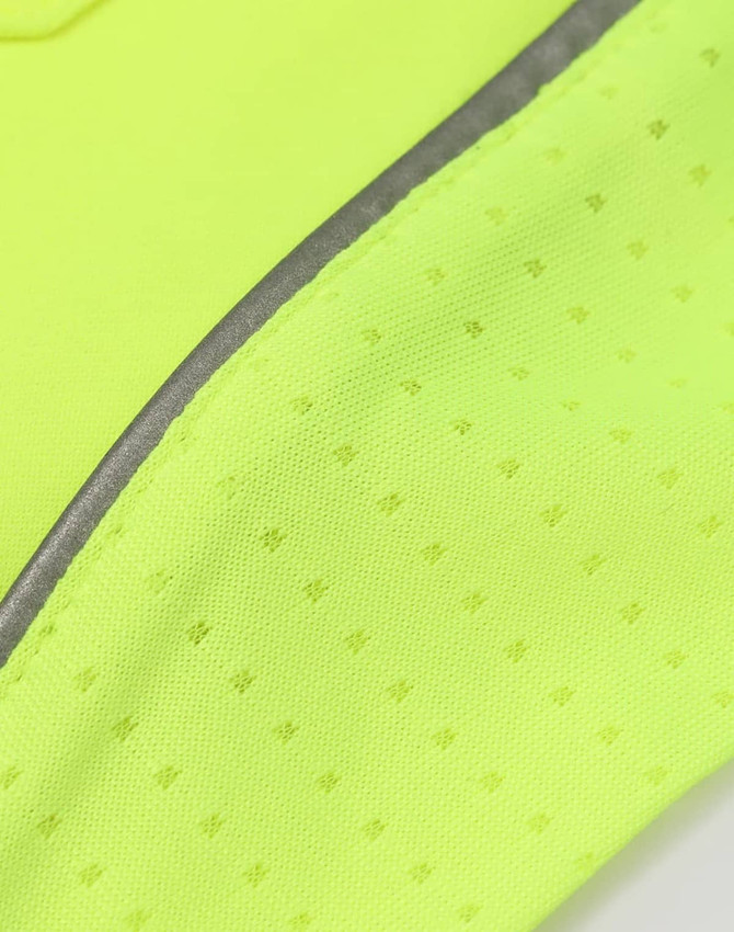 A close-up of a bright yellow fabric with small textured patterns and a reflective strip.