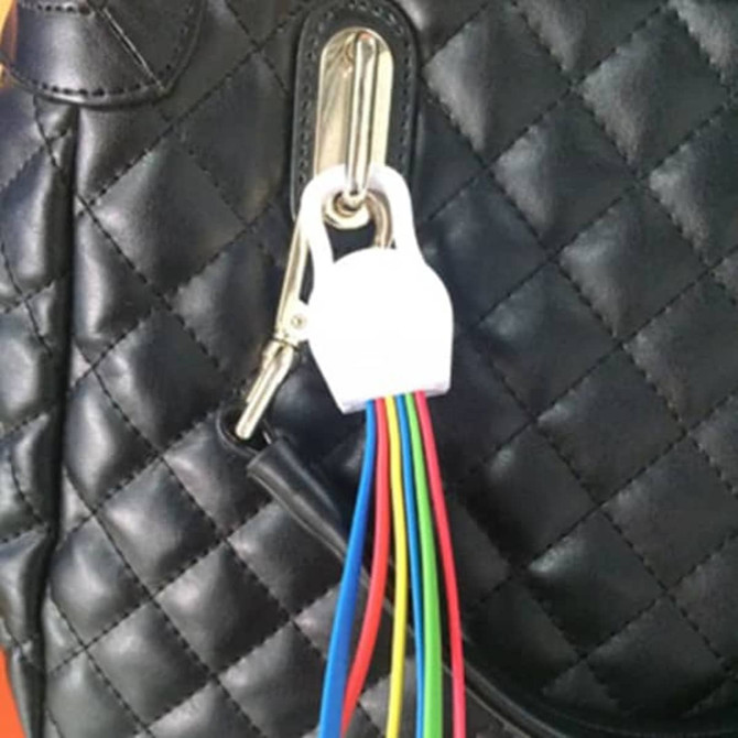 A 6-in-1 charging cable with multiple coloured wires is attached to a black, quilted bag.