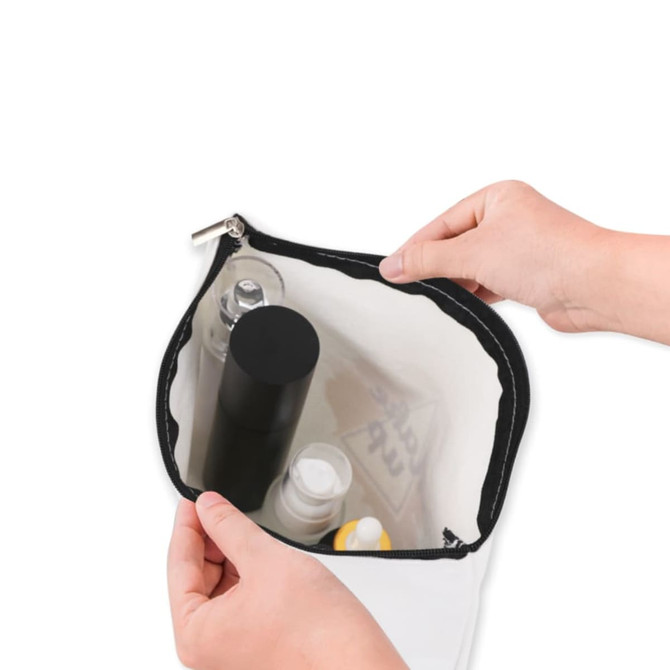 A rectangle canvas cosmetic bag in white with a black zipper, filled with various toiletry items.