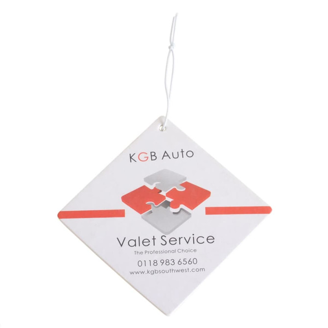 A square air freshener in white with red and grey puzzle design, featuring a hanging string and a logo.