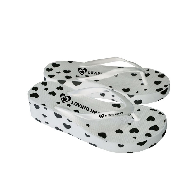 A pair of white platform thongs featuring a heart pattern and a logo on the strap.
