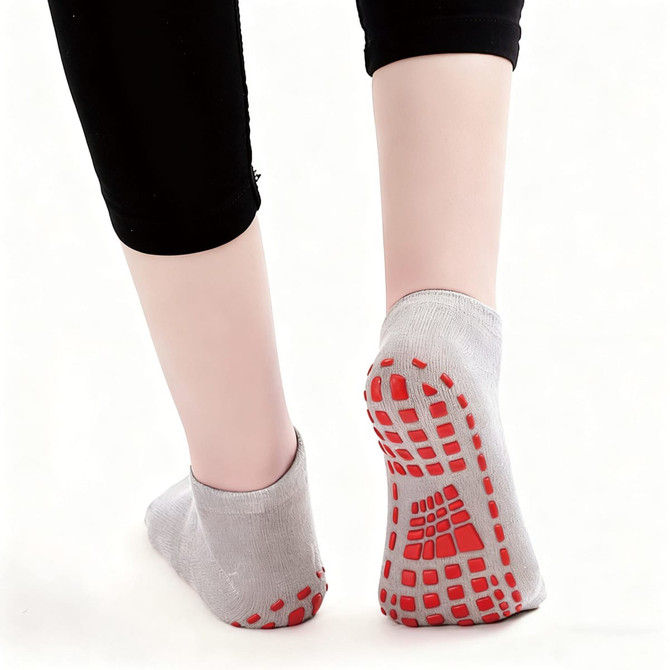 Low cut kids gripper socks in grey with red non-slip grips on the soles, displayed from behind. Low cut kids gripper socks in grey with red non-slip grips on the soles, displayed from behind.