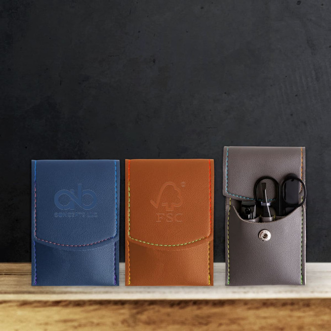 A portable manicure set featuring three leather cases in blue, orange, and grey, with scissors and nail tools visible inside.