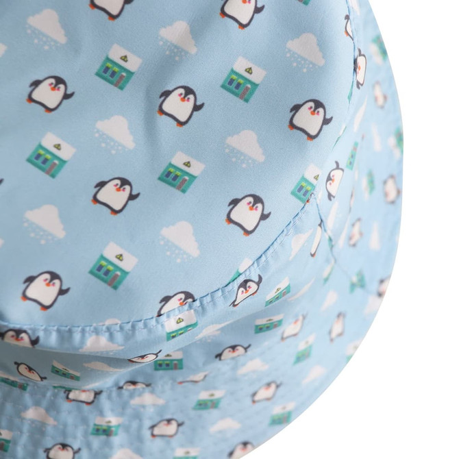 A blue bucket hat featuring a pattern of penguins and houses, with a logo on the side.