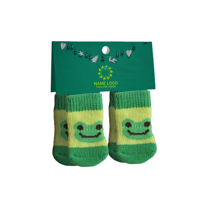 Green pet socks featuring a smiling frog design, displayed on a card with a logo and decorative elements.