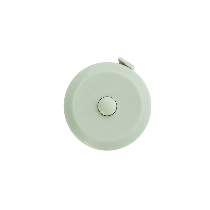 A round, light green tape measure with a white button, featuring a logo on the surface.