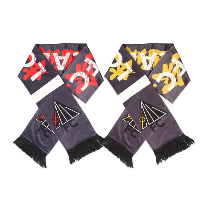A silver and black velvet scarf with decorative patterns in red, yellow, and white, featuring a logo at one end.