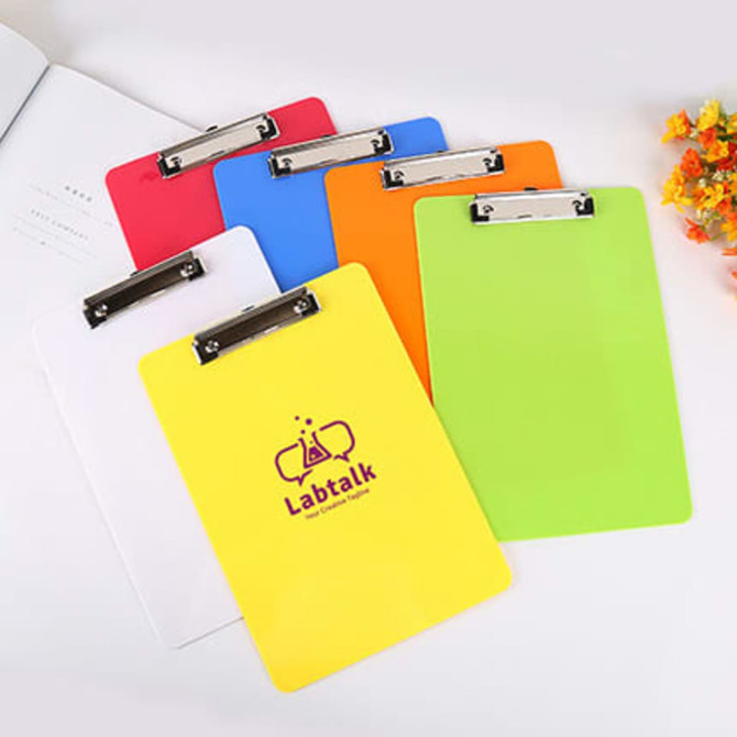 A set of colourful clipboards in red, pink, white, orange, green, and yellow, featuring a metal clip and a logo.
