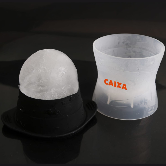 A whisky ice ball mould featuring a black base and clear container, designed for making spherical ice cubes.