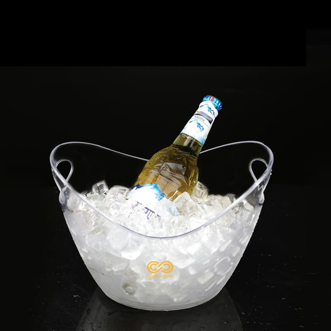 A clear ice bucket filled with ice and a bottle resting on top, featuring a handle for easy carrying.