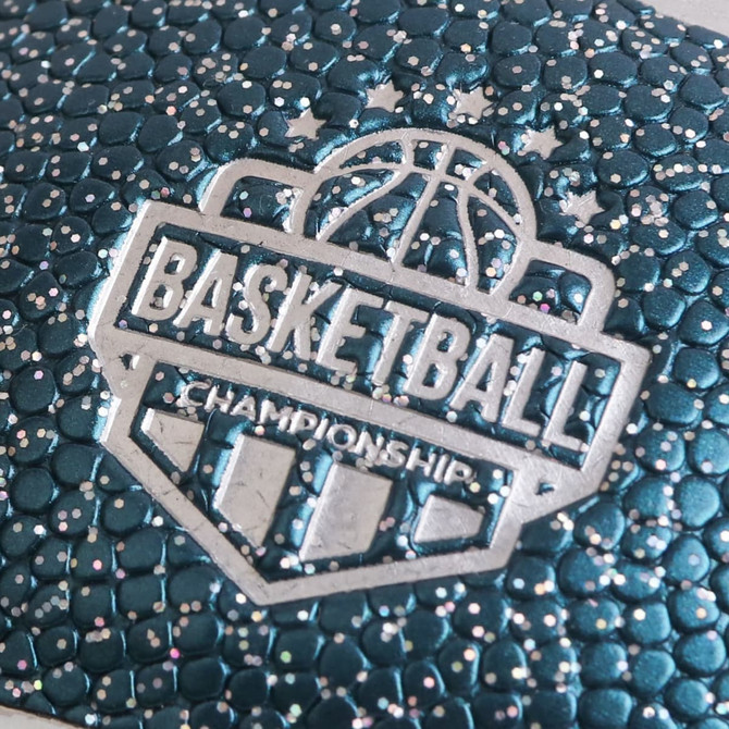 A textured mini basketball in teal with metallic accents and an embossed logo.