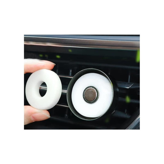 A car clip air freshener in black with a white inner circle, designed to attach to car vents.