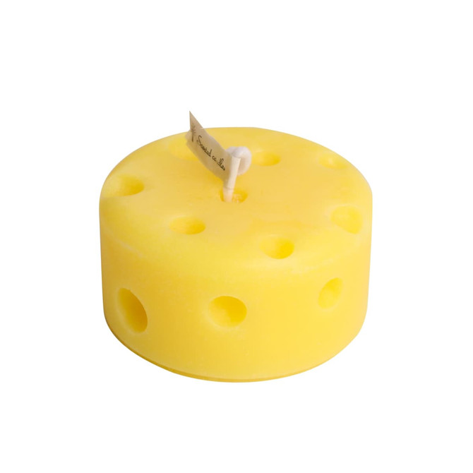 A round yellow candle designed to resemble cheese, featuring holes and a wick at the top.
