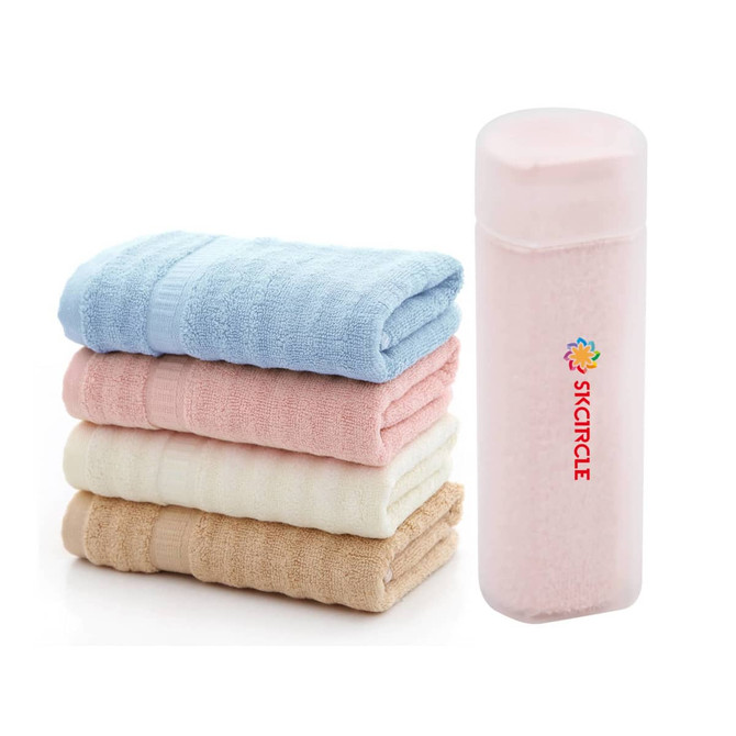 Bamboo fibre towels in blue, pink, cream, and beige stacked beside a translucent tube with a logo. Bamboo fibre towels in blue, pink, cream, and beige stacked beside a translucent tube with a logo.