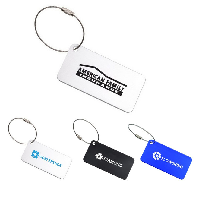 A collection of square aluminium luggage tags in white, black, and blue, each with a metal loop and branding.