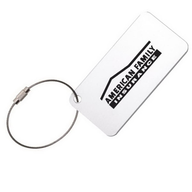 A square aluminium luggage tag in silver, featuring a logo and attached with a metal wire loop.