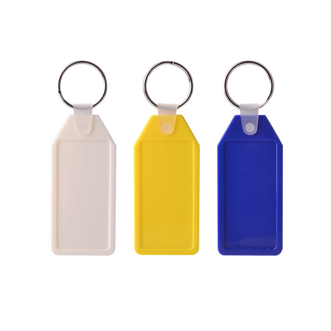 Three Long Hexagon Hard Plastic Keyrings in white, yellow, and blue, each with a silver metal keyring attachment. Three Long Hexagon Hard Plastic Keyrings in white, yellow, and blue, each with a silver metal keyring attachment.
