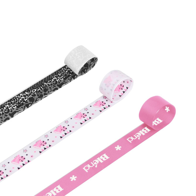 Three 22mm wide ribbed fabric ribbons in black, white, and pink, featuring various patterns and a logo.