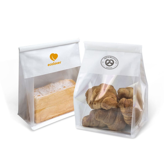 Two transparent plastic bags, one containing bread and the other containing croissants, with logos on the front. Two transparent plastic bags, one containing bread and the other containing croissants, with logos on the front.