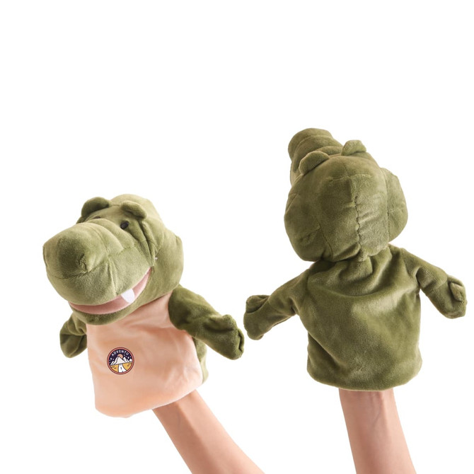 Two green crocodile hand puppets are held up, featuring plush fabric and a logo on one side.